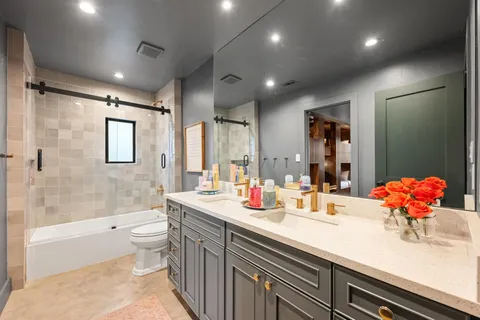 a bathroom with a double vanity sink mirror double and bathtub