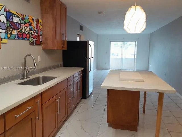 a kitchen that has a sink and a stove top oven