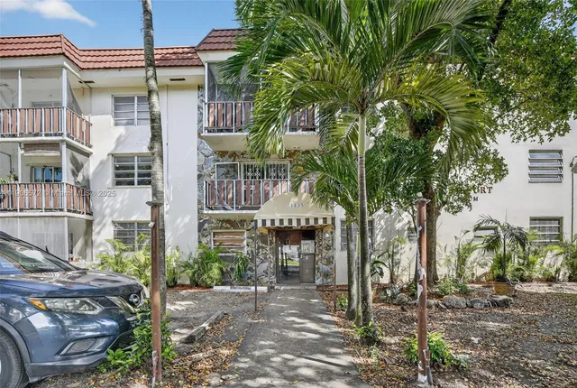 a front view of a house with a tree