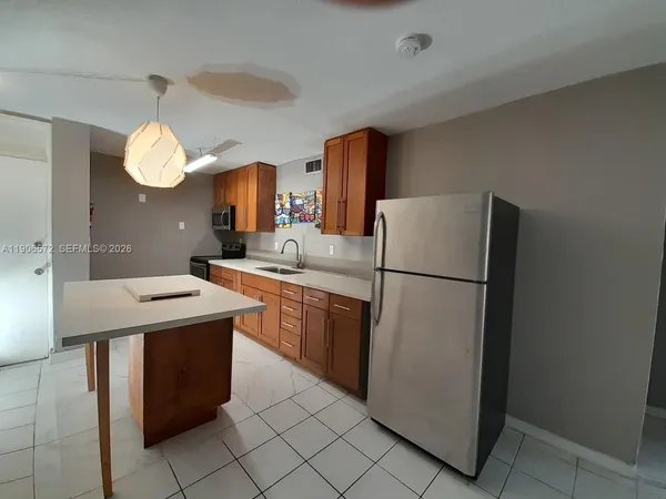 a kitchen with cabinets a refrigerator and a sink