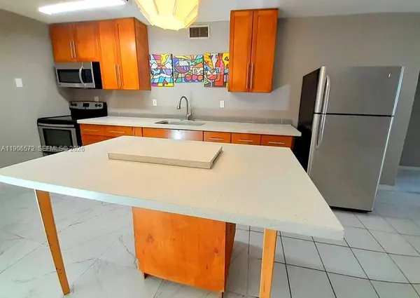 a kitchen with stainless steel appliances a refrigerator and a sink