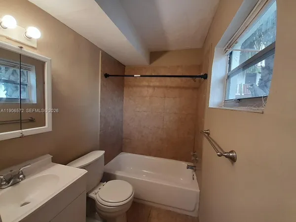 a white toilet sitting next to a bath tub