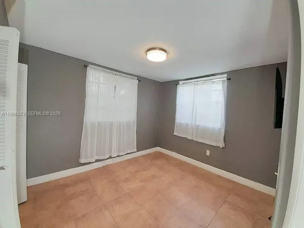 an empty room with a fan and a window