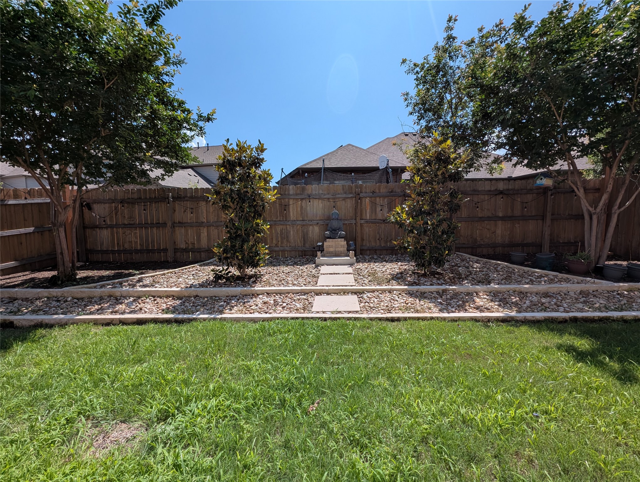 14502 McCoy Loop Austin, TX 78717 - Photo 24 of 26 Expansive backyard featuring a manicured lawn, a wood privacy fence, and mature trees