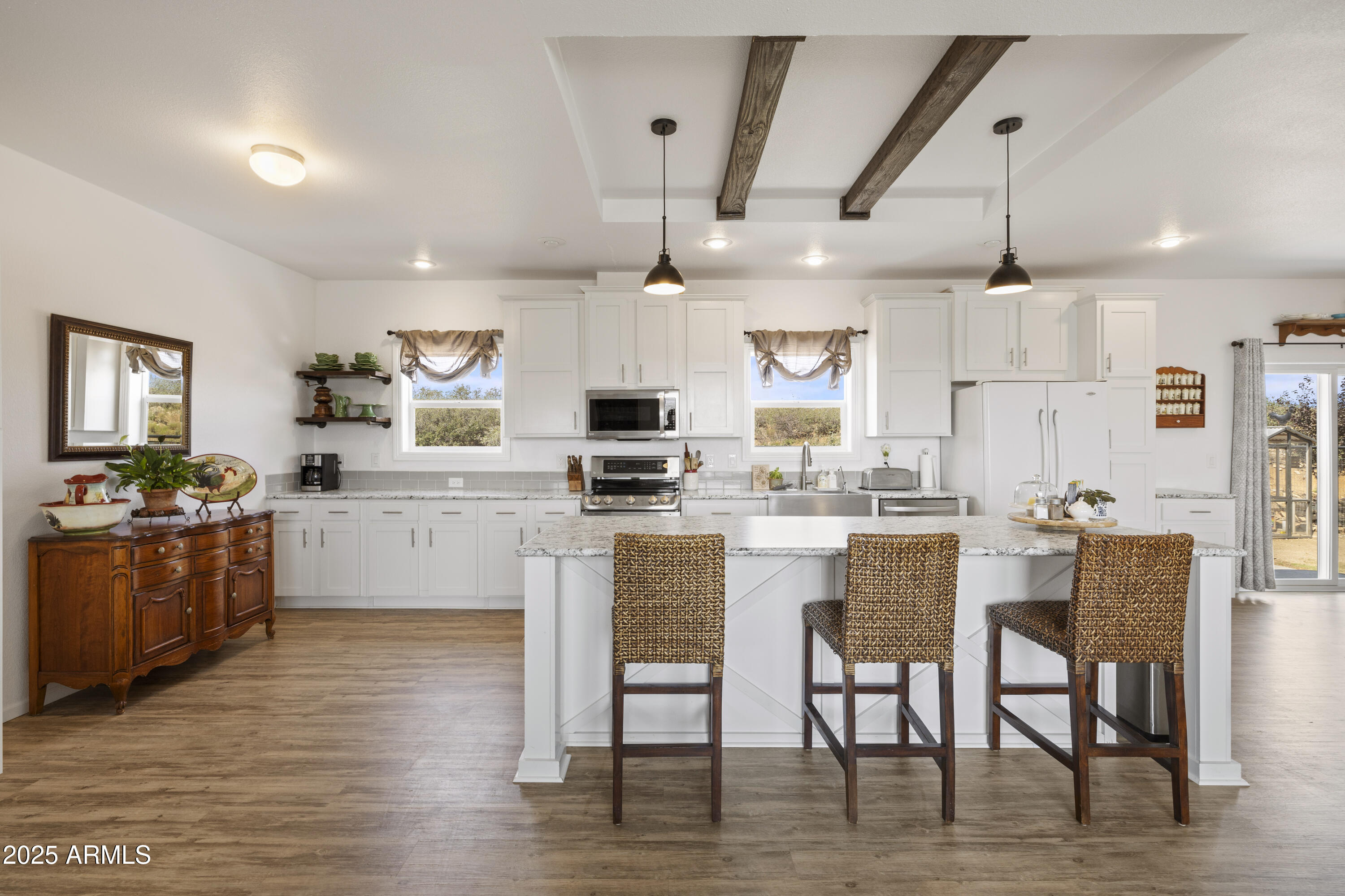 1235 North Harvest Road Dewey, AZ 86327 - Photo 5 of 37 a kitchen with stainless steel appliances kitchen island granite countertop a table chairs and a refrigerator