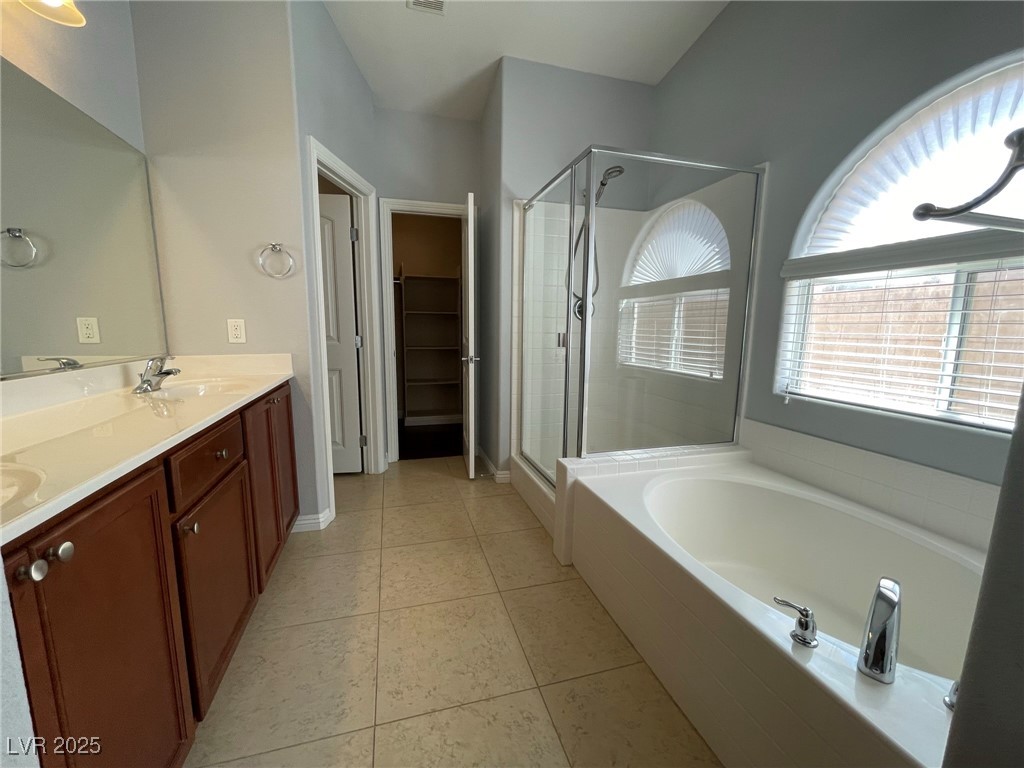 92 Whitetail Archery Avenue North Las Vegas, NV 89084 - Photo 18 of 33 Bathroom featuring a shower stall, double vanity, a bath, and a walk in closet