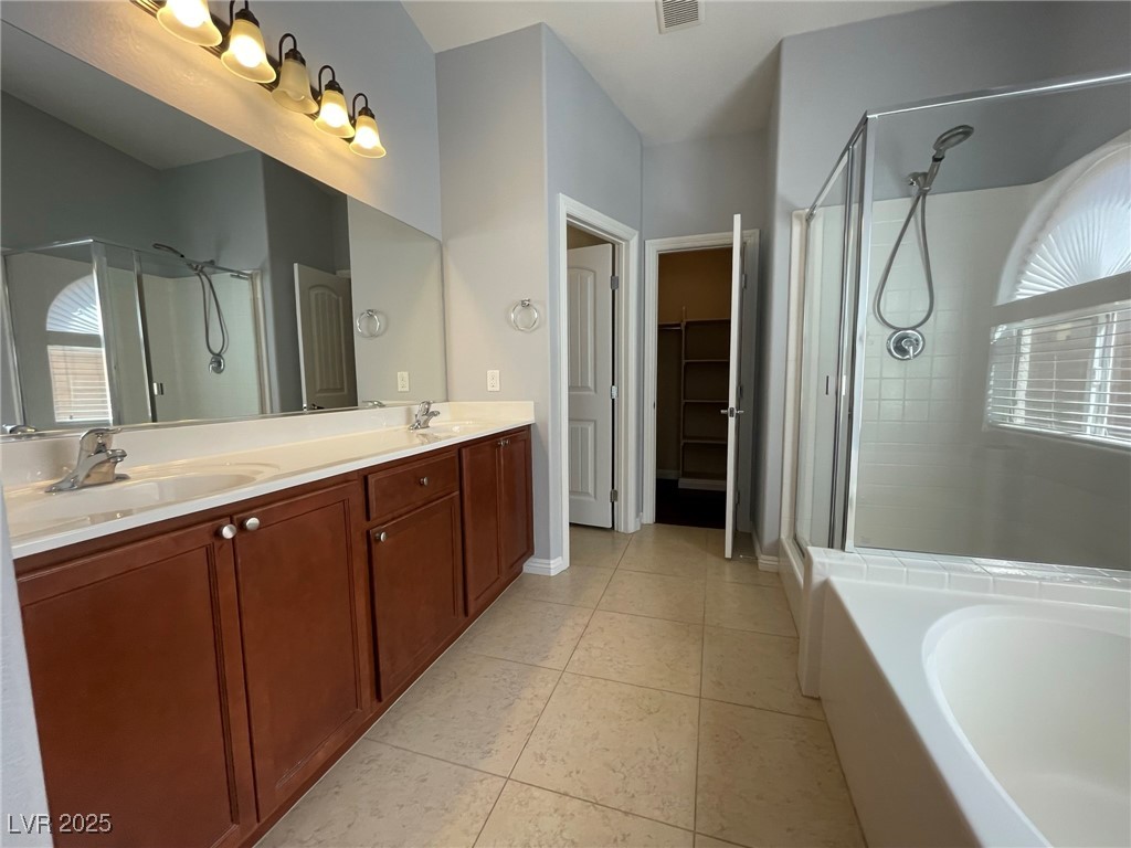 92 Whitetail Archery Avenue North Las Vegas, NV 89084 - Photo 19 of 33 Full bathroom featuring a shower stall, light tile patterned flooring, a bath, and double vanity