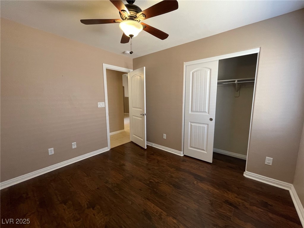 92 Whitetail Archery Avenue North Las Vegas, NV 89084 - Photo 24 of 33 Unfurnished bedroom with dark wood-type flooring, ceiling fan, and a closet
