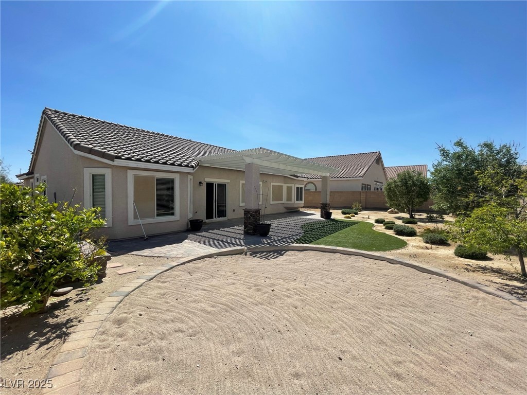92 Whitetail Archery Avenue North Las Vegas, NV 89084 - Photo 31 of 33 Rear view of house featuring a patio area, stucco siding, a tiled roof, and a pergola