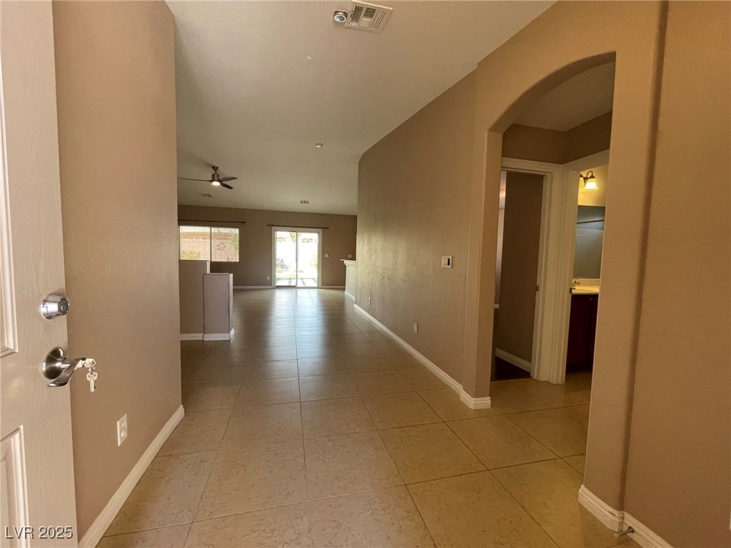 92 Whitetail Archery Avenue North Las Vegas, NV 89084 - Photo 4 of 33 Hallway featuring arched walkways and light tile patterned flooring