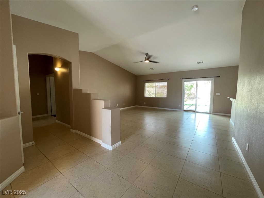 92 Whitetail Archery Avenue North Las Vegas, NV 89084 - Photo 5 of 33 Empty room with arched walkways, light tile patterned floors, ceiling fan, and lofted ceiling