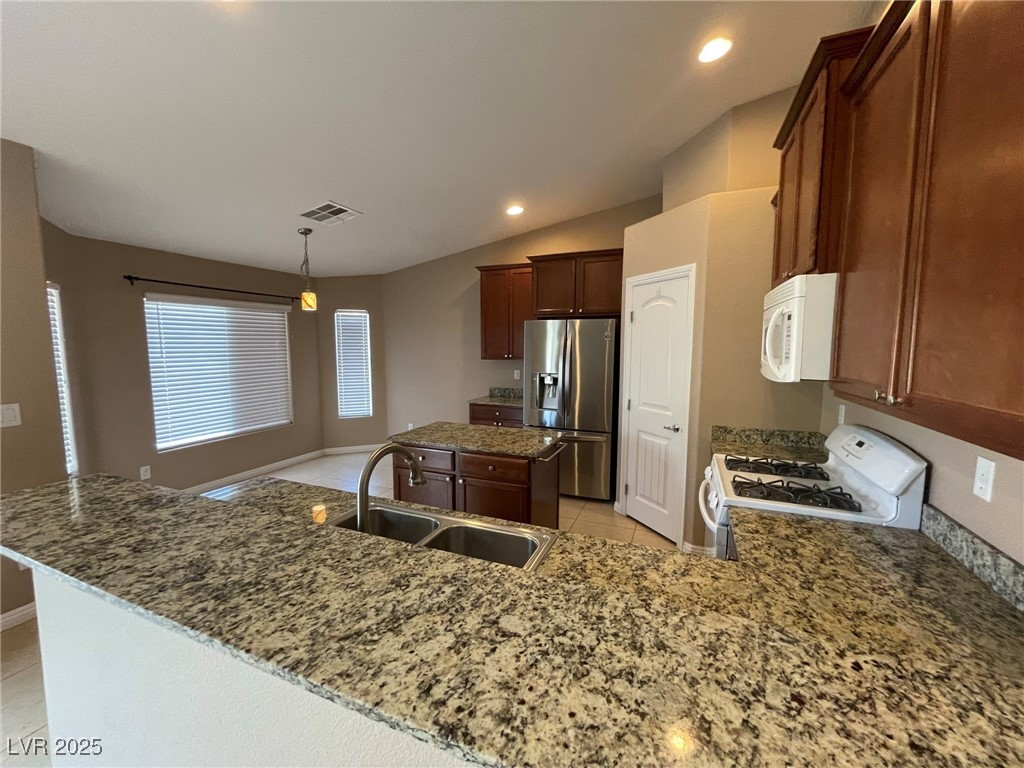 92 Whitetail Archery Avenue North Las Vegas, NV 89084 - Photo 8 of 33 Kitchen featuring a center island, light tile patterned floors, white appliances, lofted ceiling, and pendant lighting