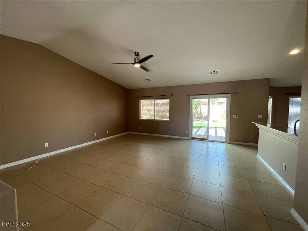 92 Whitetail Archery Avenue North Las Vegas, NV 89084 - Photo 9 of 33 Empty room featuring lofted ceiling, light tile patterned floors, and a ceiling fan