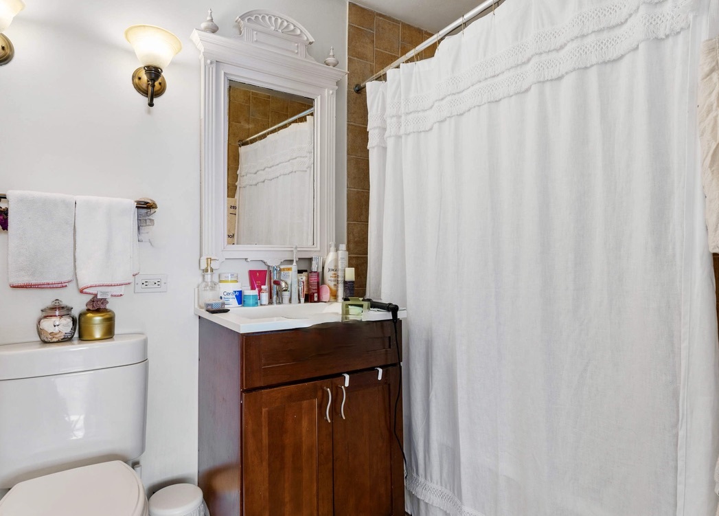 655 West Irving Park Road, Unit 4517 Chicago, IL 60613 - Photo 9 of 27 a bathroom with a sink toilet vanity and mirror
