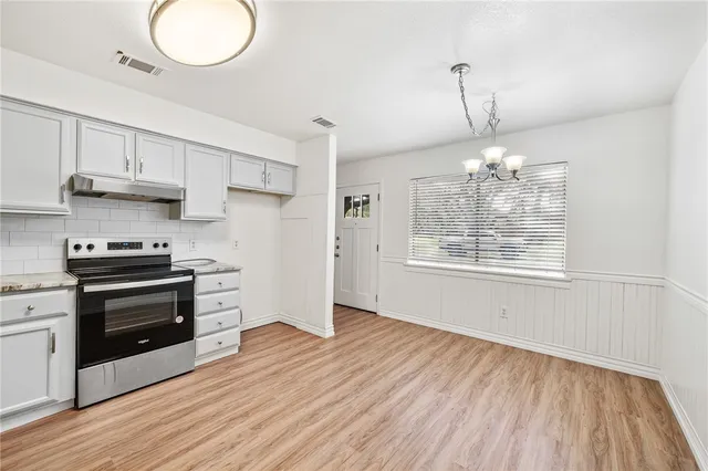 a kitchen with stainless steel appliances a stove and wooden floor