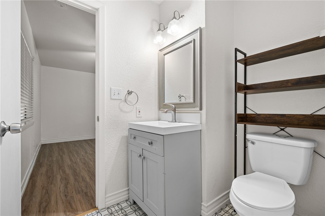 2551 Poinsetta Place Ingleside, TX 78362 - Photo 9 of 21 a bathroom with a toilet a sink a mirror and vanity
