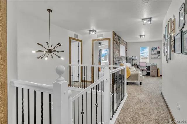 a view of a hallway with workspace and stairs