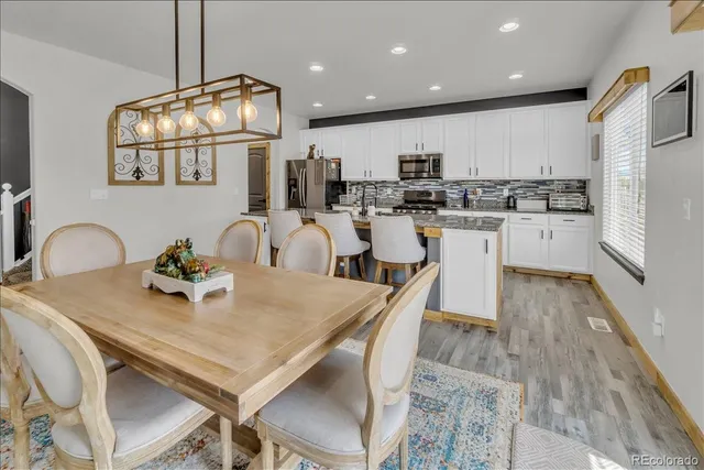 a kitchen with stainless steel appliances granite countertop a kitchen island hardwood floor sink and stove