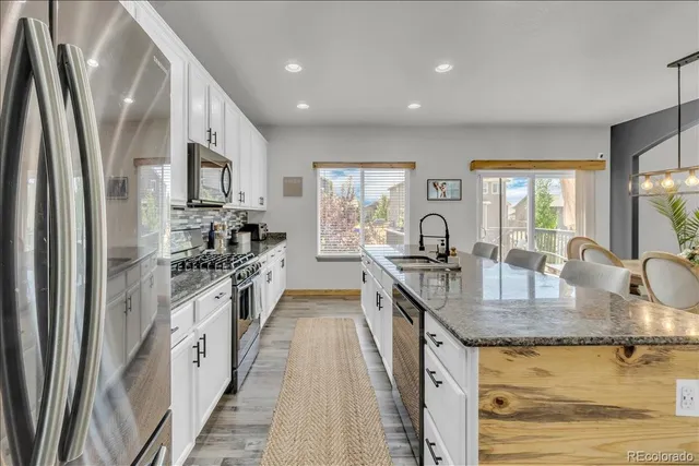 a kitchen with stainless steel appliances granite countertop a sink stove and refrigerator