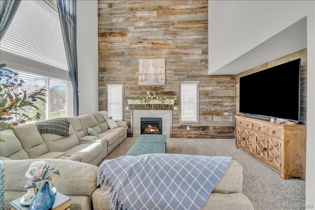 a living room with furniture a flat screen tv and a fireplace