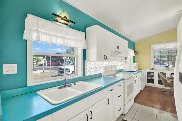 a large white kitchen with a large window