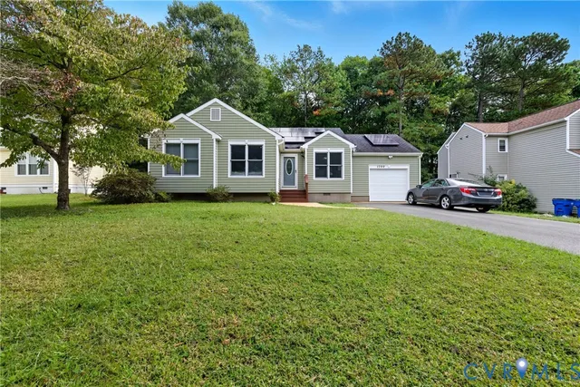 a front view of a house with a garden and trees
