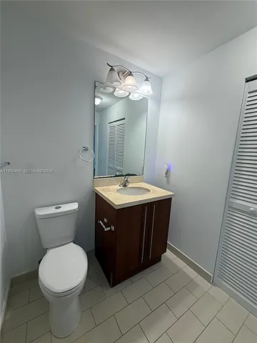 a bathroom with a sink vanity mirror and toilet