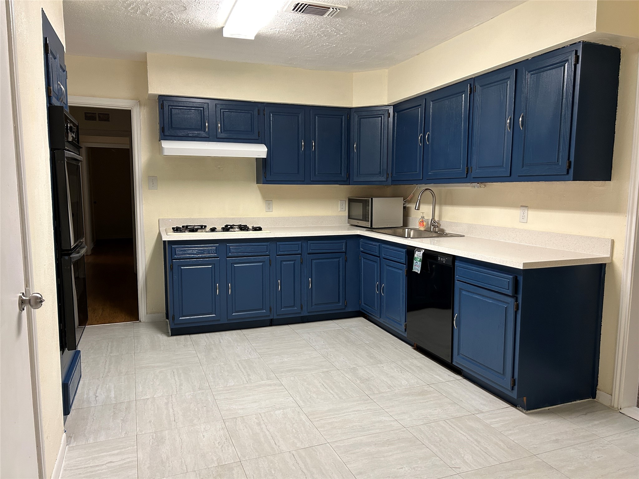 5806 Beldart Street Houston, TX 77033 - Photo 12 of 23 a kitchen with a sink and wooden cabinets