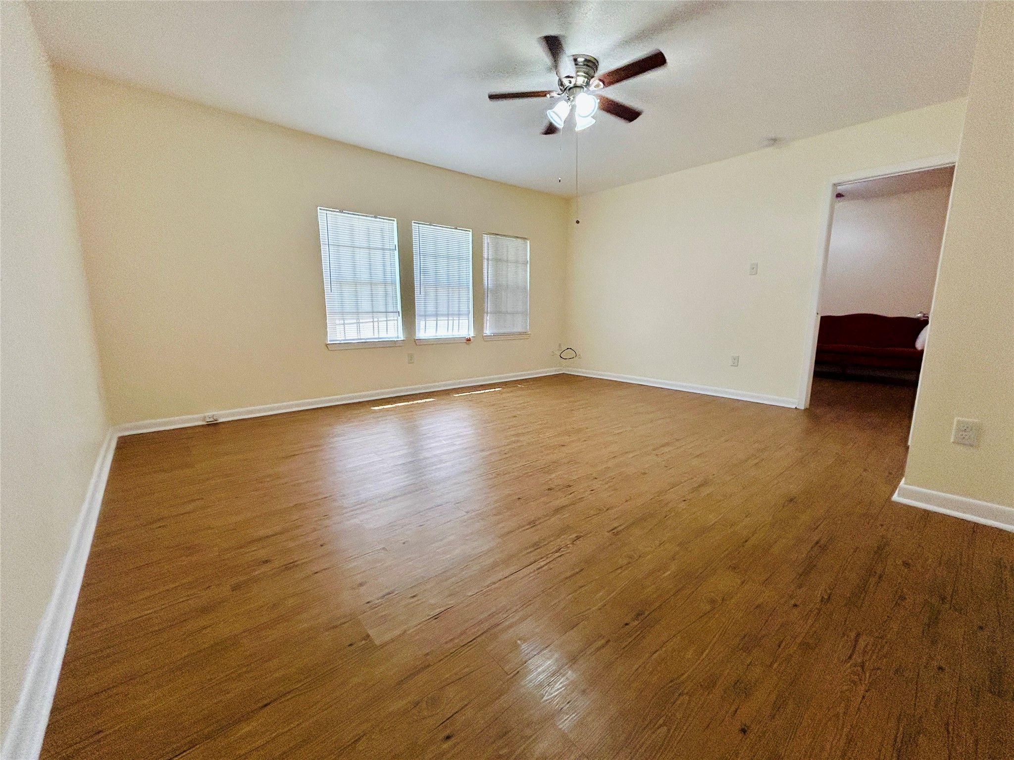 5806 Beldart Street Houston, TX 77033 - Photo 17 of 23 a view of an empty room with wooden floor and a window