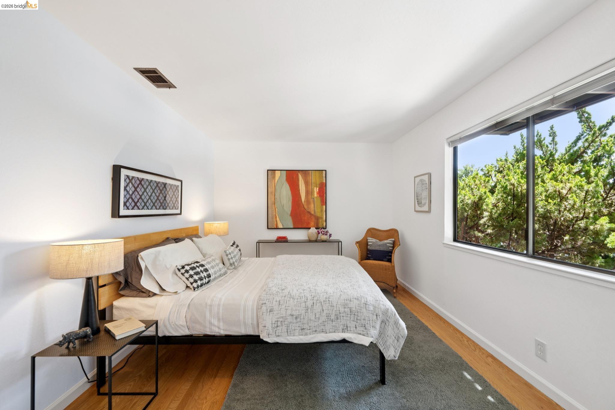 1340 Henry Street Berkeley, CA 94709 - Photo 35 of 52 Bright room featuring wood-finish flooring, a white ceiling, a large window, a ceiling vent, and white baseboards