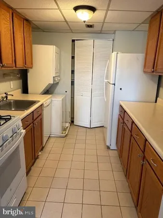 a kitchen with a sink a refrigerator and cabinets