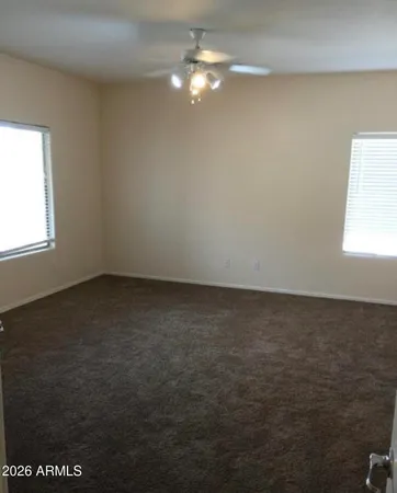 en empty room with windows and fan