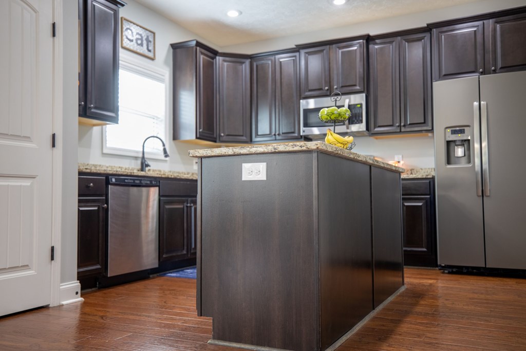 9660 Yellow Pine Road Midland, GA 31820 - Photo 9 of 27 a kitchen with stainless steel appliances granite countertop a refrigerator a stove and a sink with wooden floors