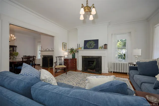 a living room with furniture a fireplace and a chandelier
