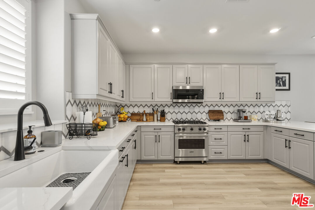 756 Daniel Freeman Circle Inglewood, CA 90301 - Photo 14 of 54 a kitchen with kitchen island white cabinets appliances and a sink