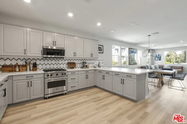 a kitchen with sink stove and cabinets