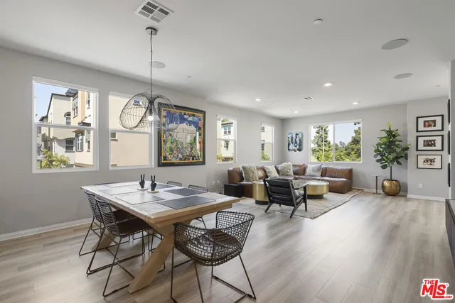 a living room with furniture two window and a wooden floor
