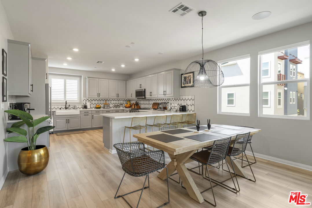 756 Daniel Freeman Circle Inglewood, CA 90301 - Photo 25 of 54 a kitchen with stainless steel appliances granite countertop a stove a kitchen island a dining table and chairs with wooden floor