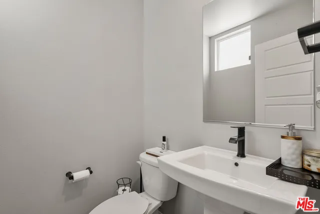 a bathroom with a sink a toilet and mirror