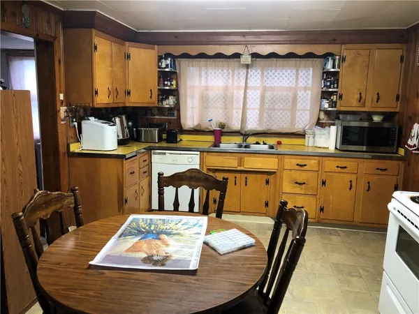 a kitchen with a table chairs and a wooden cabinets