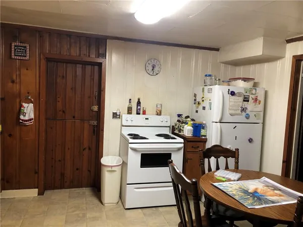 a kitchen with a table chairs refrigerator and cabinets