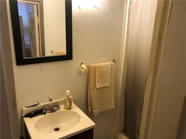 a bathroom with a sink a mirror and a shower