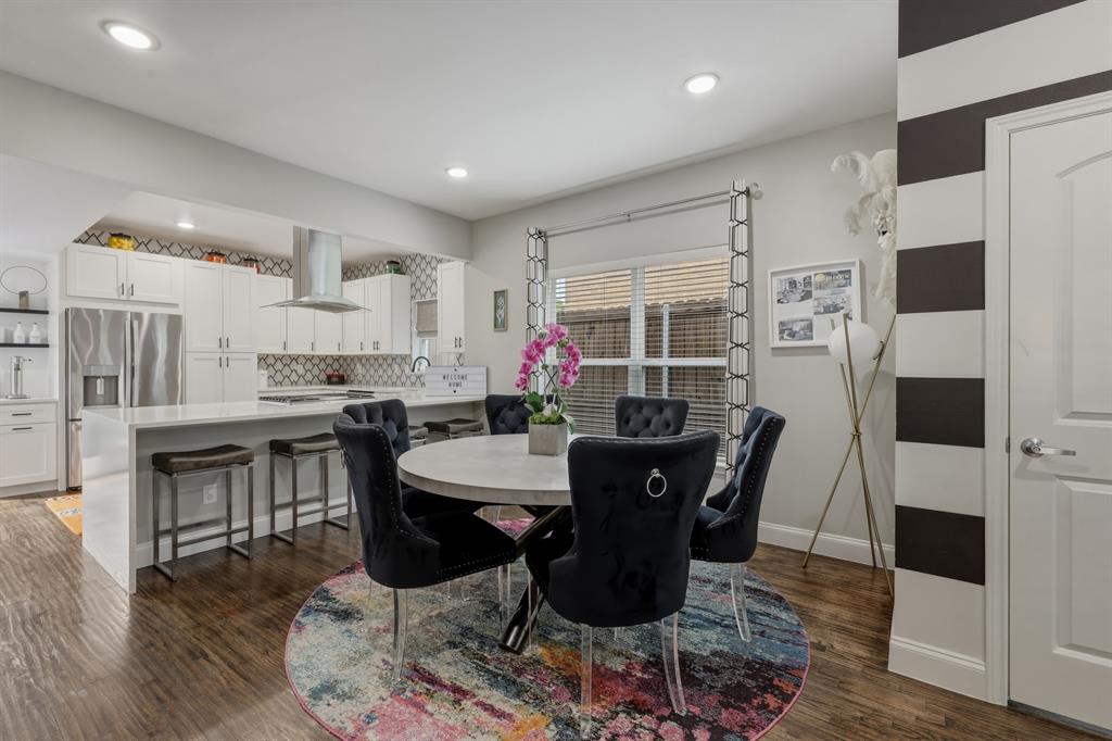 5914 Goodwin Avenue Dallas, TX 75206 - Photo 6 of 32 a kitchen with stainless steel appliances kitchen island granite countertop a dining table chairs and a refrigerator