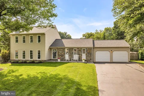 a view of a house with a big yard and large tree