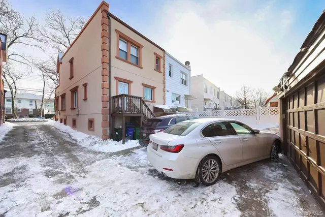 a view of a white house with a yard and parking space