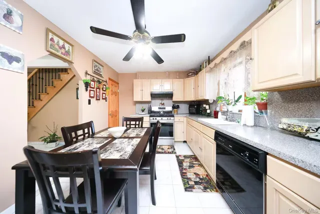 a kitchen with stainless steel appliances granite countertop a stove top oven a sink a dining table and chairs with wooden floor