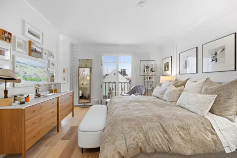 a spacious bedroom with a bed a couch and dresser