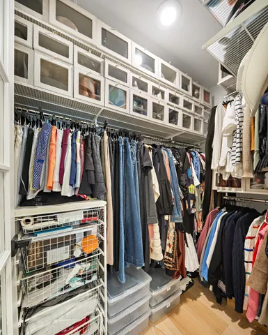 a view of walk in closet with clothes and shoes