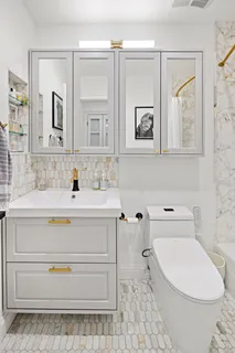 a bathroom with a sink a toilet and mirror