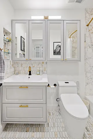 a bathroom with a sink a toilet and mirror